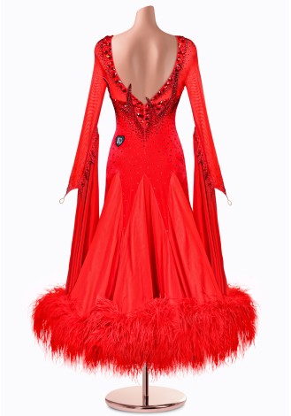 A stunning red ballroom dance gown with long sleeves, a beaded bodice, and a dramatic feather trim.