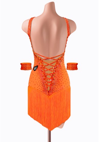Vibrant orange Latin dance dress with intricate beading and fringed skirt. Perfect for a fiery performance.