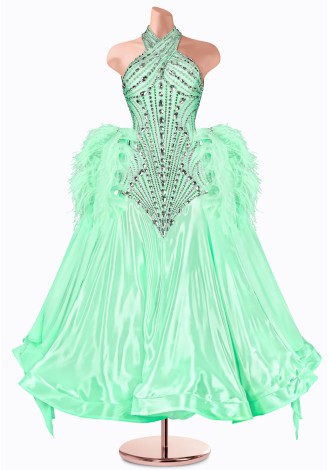 A stunning mint green ballroom dance gown, embellished with sparkling crystals and delicate feather accents. The halter neck an