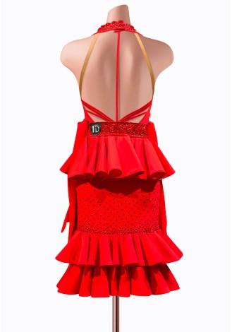 This fiery red Latin dance dress is adorned with dazzling rhinestones and features a stunning peplum waist and ruffled skirt. P